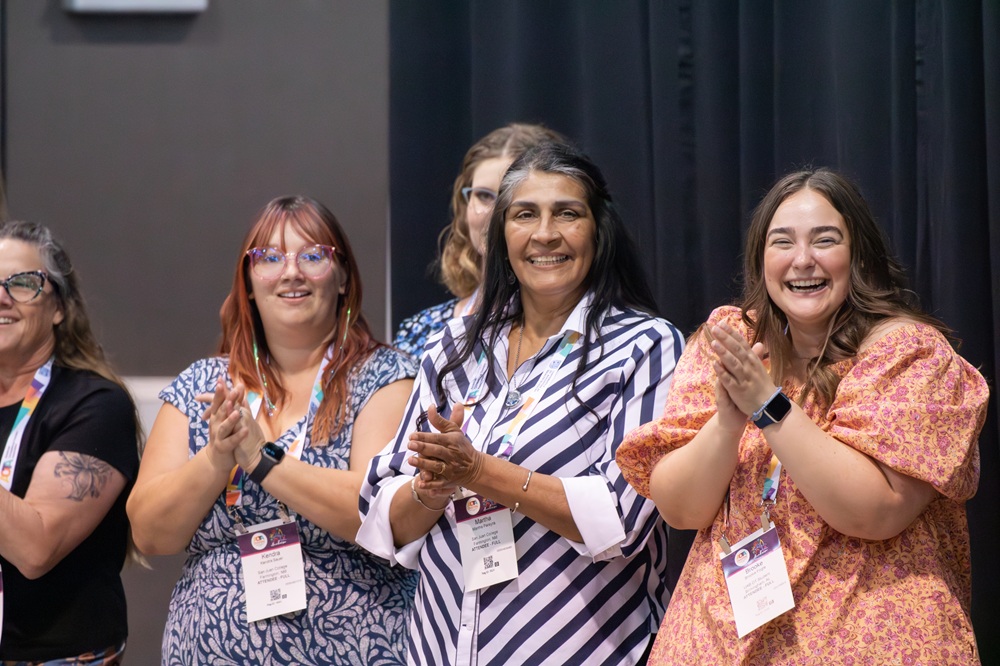 Group of three smiling and clapping