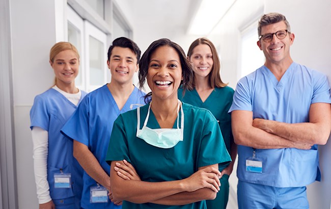 Smiling healthcare workers in scrubs looking at camera