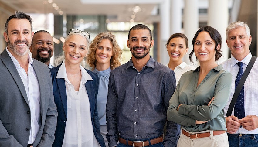 Large diverse group of coworkers smiling at camera inside an office