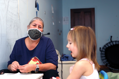 Grandmother and child participate in a relationship building activity together. Grandmother listens as child explains her drawing.