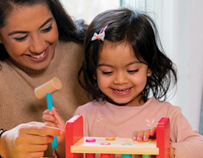 Woman and child playing with a hammer and block toy