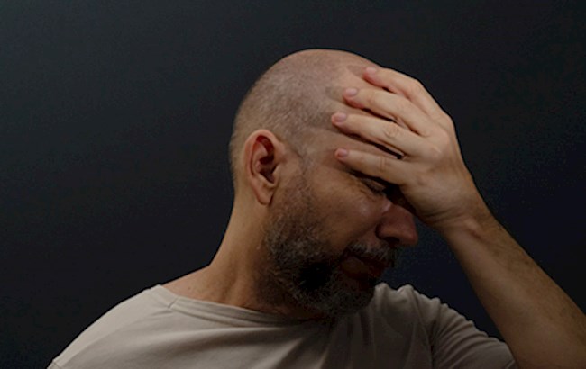 Man holding head with hand feeling trauma