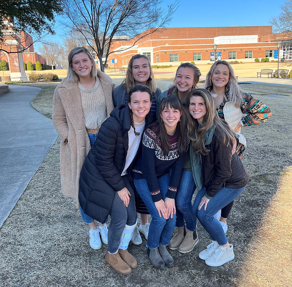 Seven female OT students standing together outside